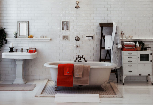 Detalles naranjas en un baño blanco