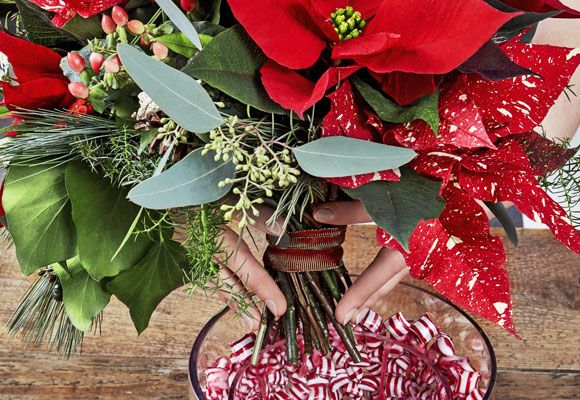 Un centro de Navidad con chuches y ponsettias